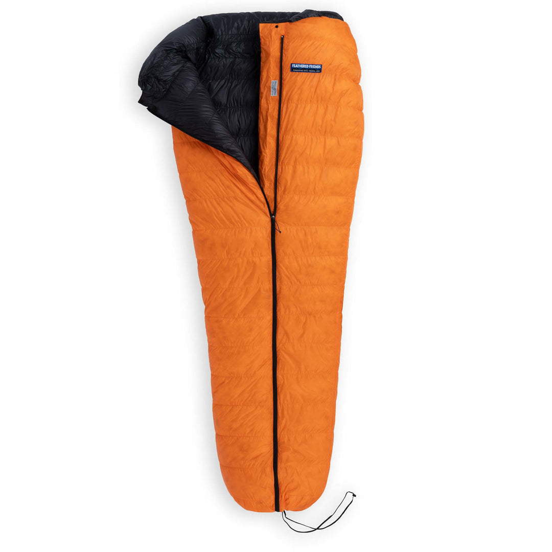 Partially unzipped Feathered Friends Flicker UL Ultralight Down Quilt Sleeping Bag in Flame orange with cinched footbox on a white background
