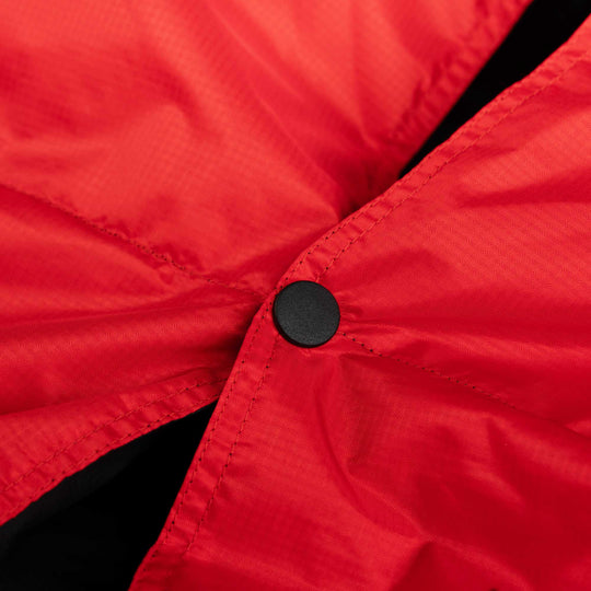 Close up of a snap button detail on Red and Black Feathered Friends down blanket