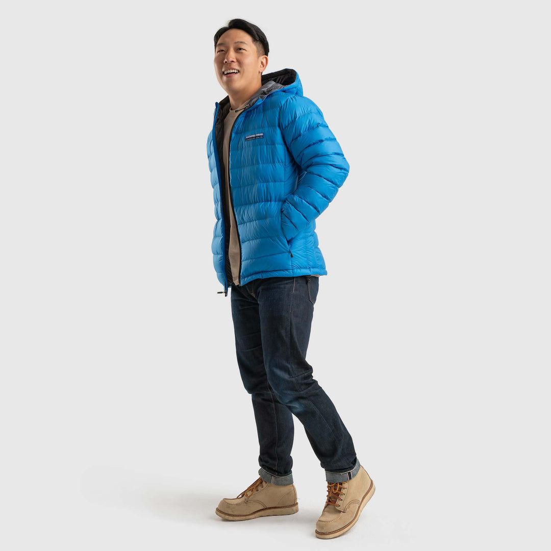 Full view studio photo of a man wearing blue sky color Feathered Friends Eos Jacket