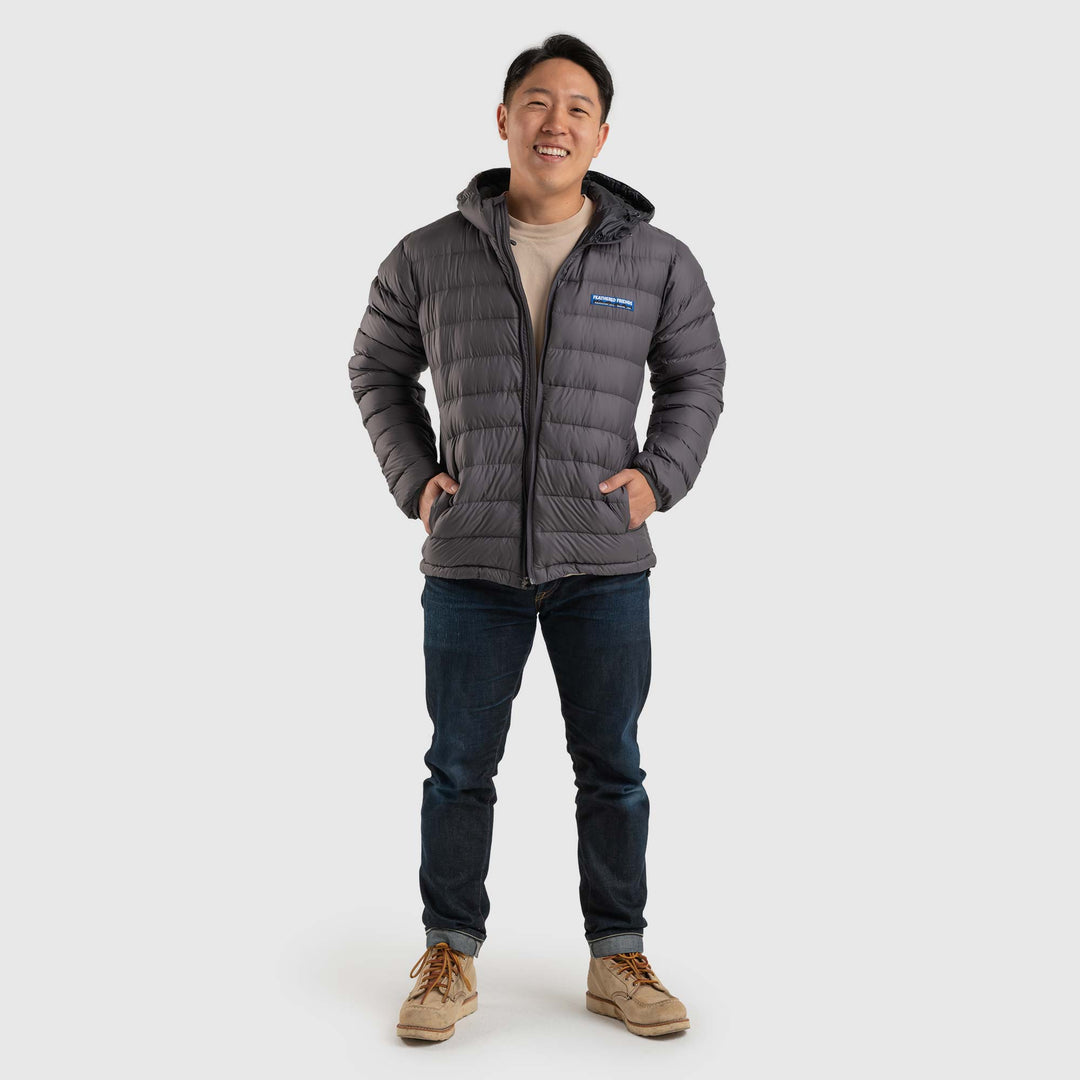 Front view studio photo of a man wearing Steel Gray color Feathered Friends Eos Jacket