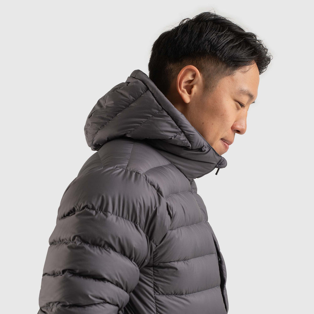Side view studio photo of a man wearing Steel Gray color Feathered Friends Eos Jacket