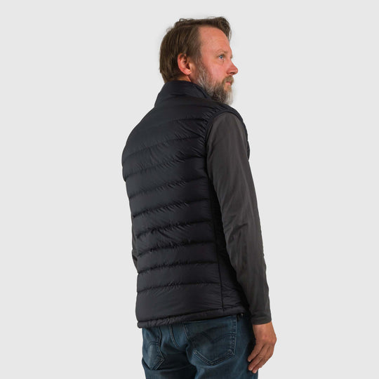 Studio back view of a man wearing a black Men's Feathered Friends Eos Vest