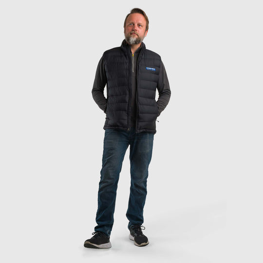 Studio front view of a man wearing a black Men's Feathered Friends Eos Vest