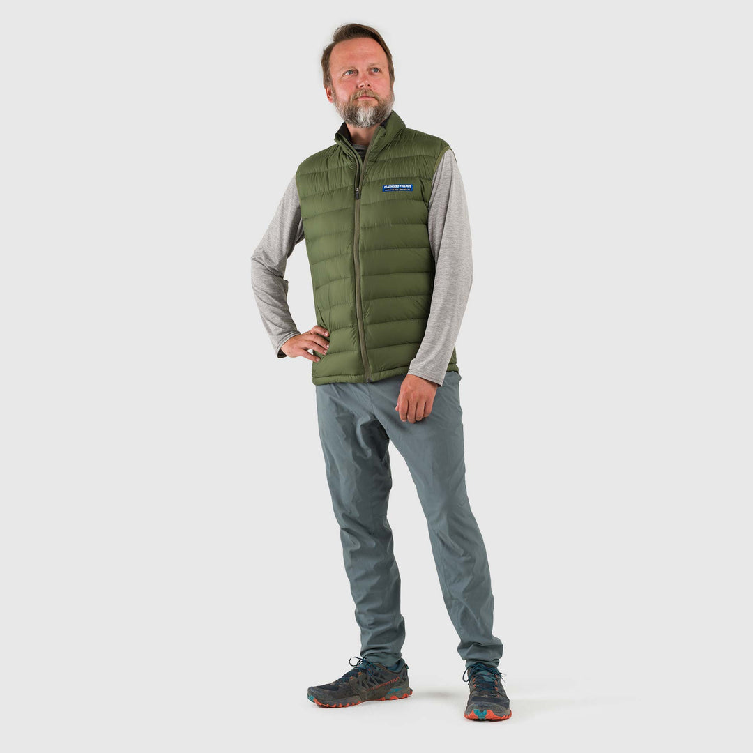 Studio front view of a man wearing a chive green Men's Feathered Friends Eos Vest