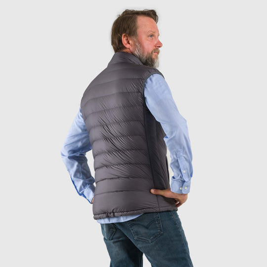Studio back view of a man wearing a steel gray Men's Feathered Friends Eos Vest