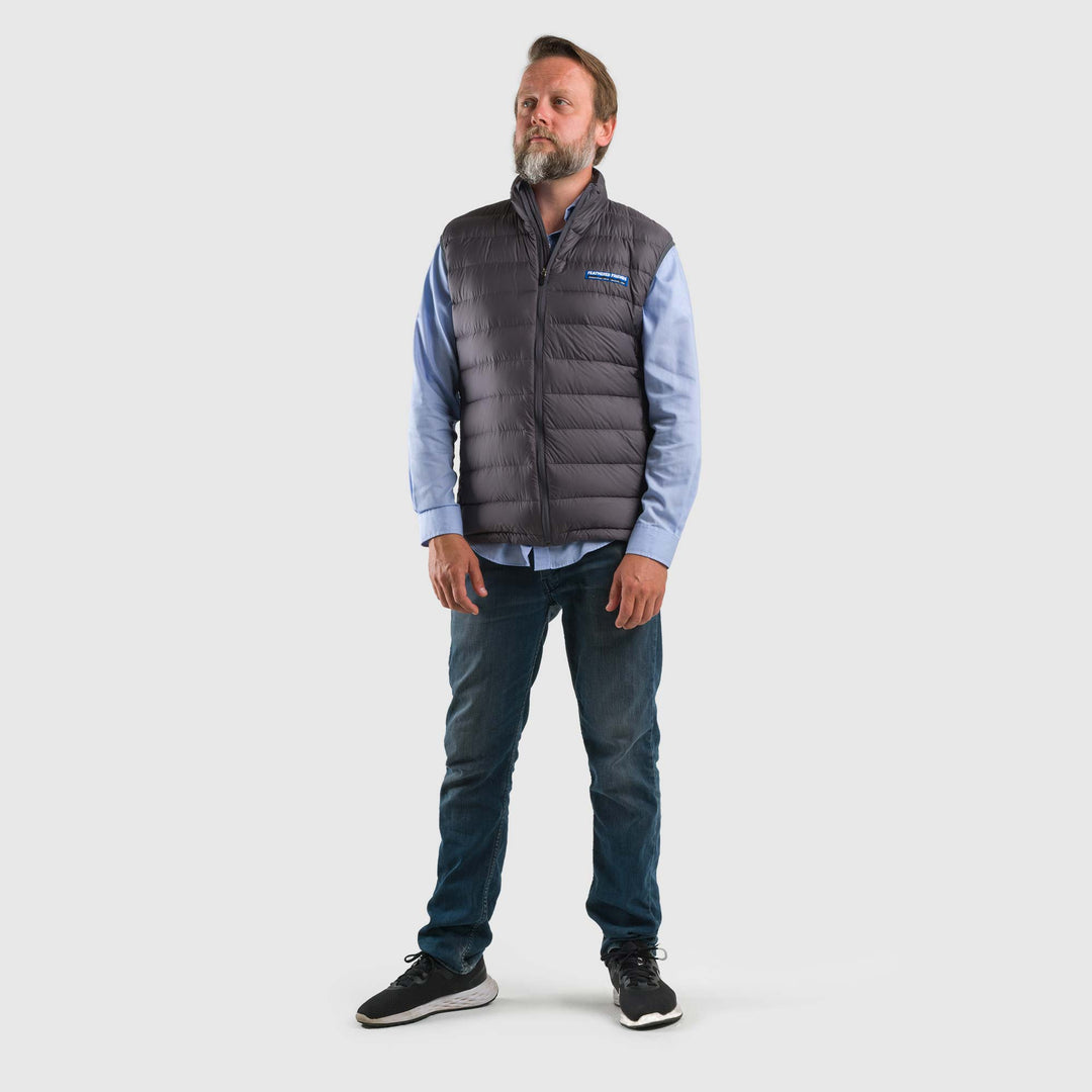 Studio front view of a man wearing a steel gray Men's Feathered Friends Eos Vest