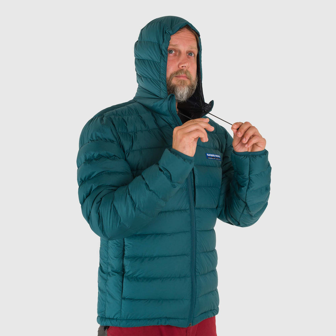 Studio front hood-detail view of man wearing a deep teal Men's Feathered Friends Eos Down Jacket