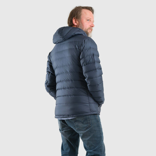 Studio back view of man wearing a midnight blue Men's Feathered Friends Eos Down Jacket