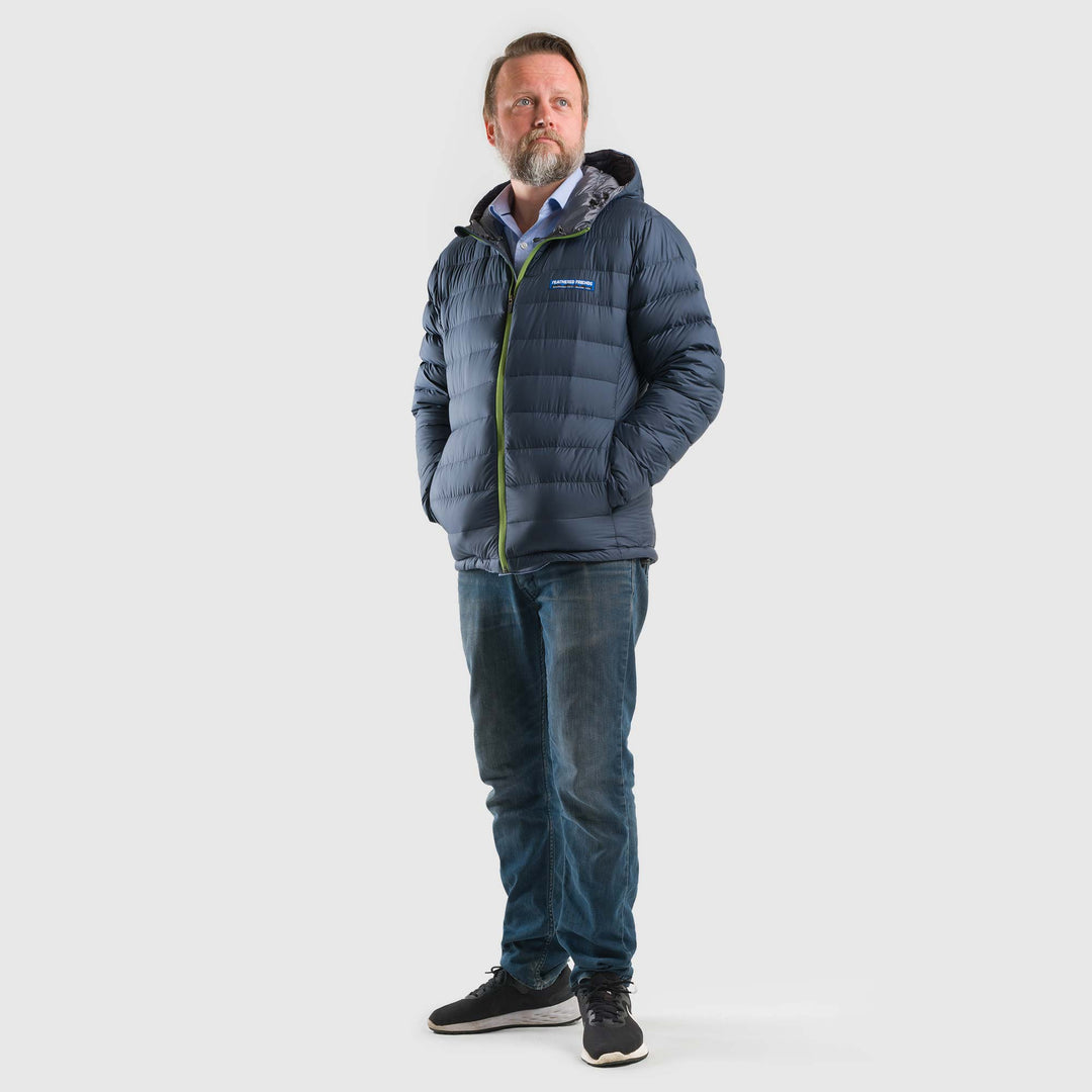 Studio front view of man wearing a midnight blue Men's Feathered Friends Eos Down Jacket