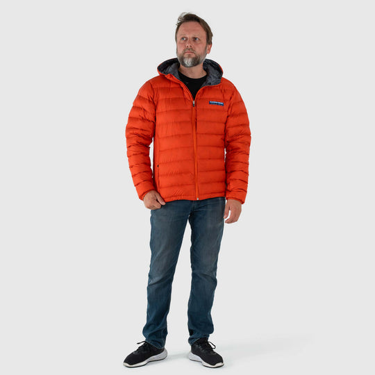 Studio front view of man wearing a rorange Men's Feathered Friends Eos Down Jacket