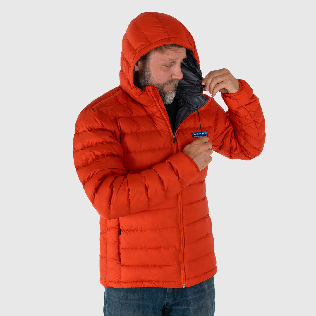 Studio front hood detail view of man wearing a rorange Men's Feathered Friends Eos Down Jacket