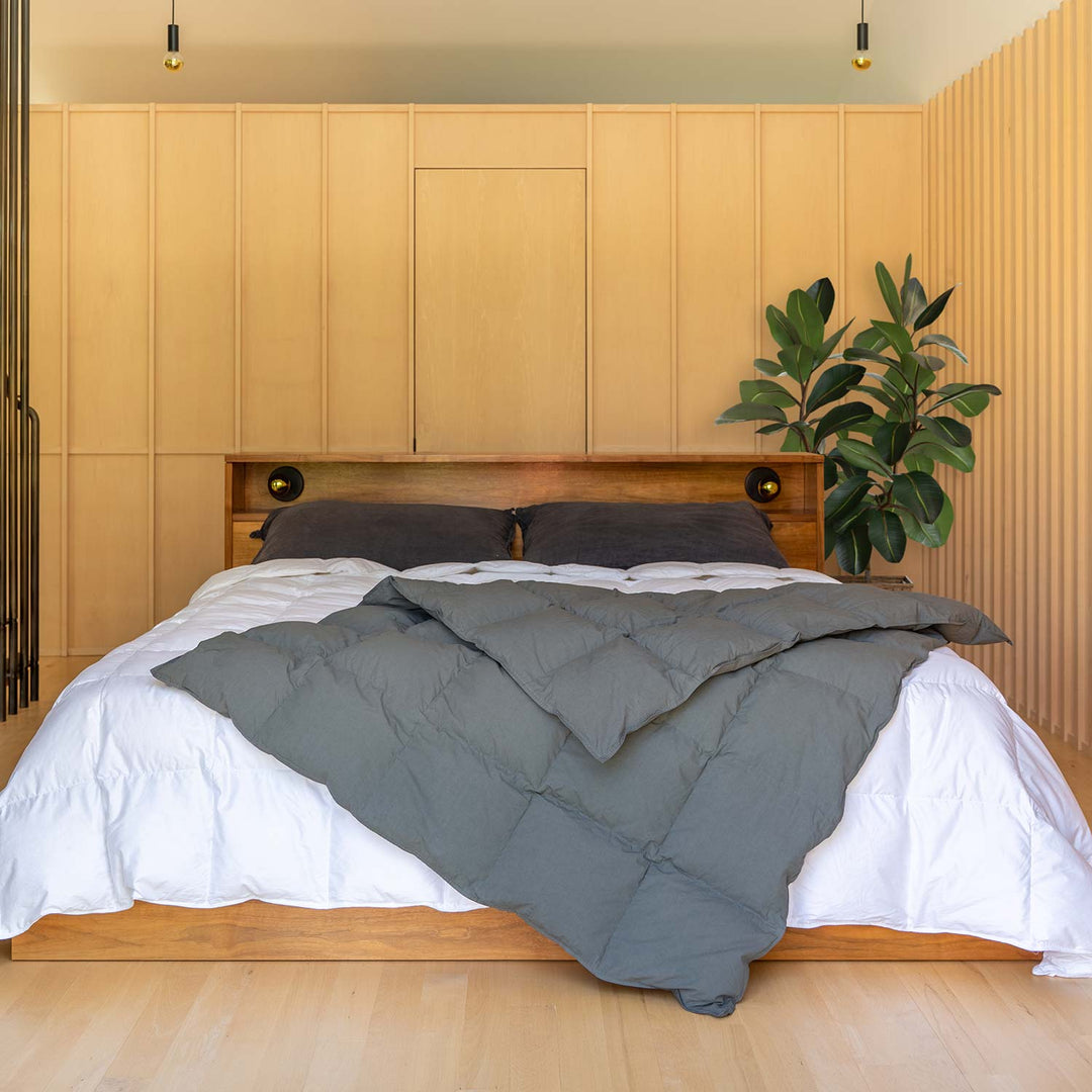 Bedroom with wood panel walls with a bed and Cascade gray down throw blanket