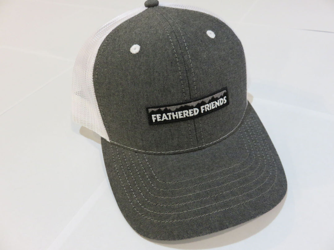 Studio image Feathered Friends Pro Style Mountain Logo Trucker Hat white and chambray black colors
