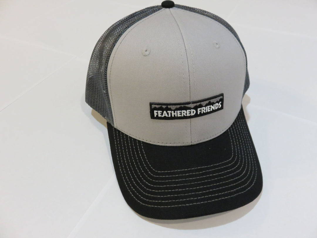 Studio image Feathered Friends Pro Style Mountain Logo Trucker Hat gray, black, and charcoal colors