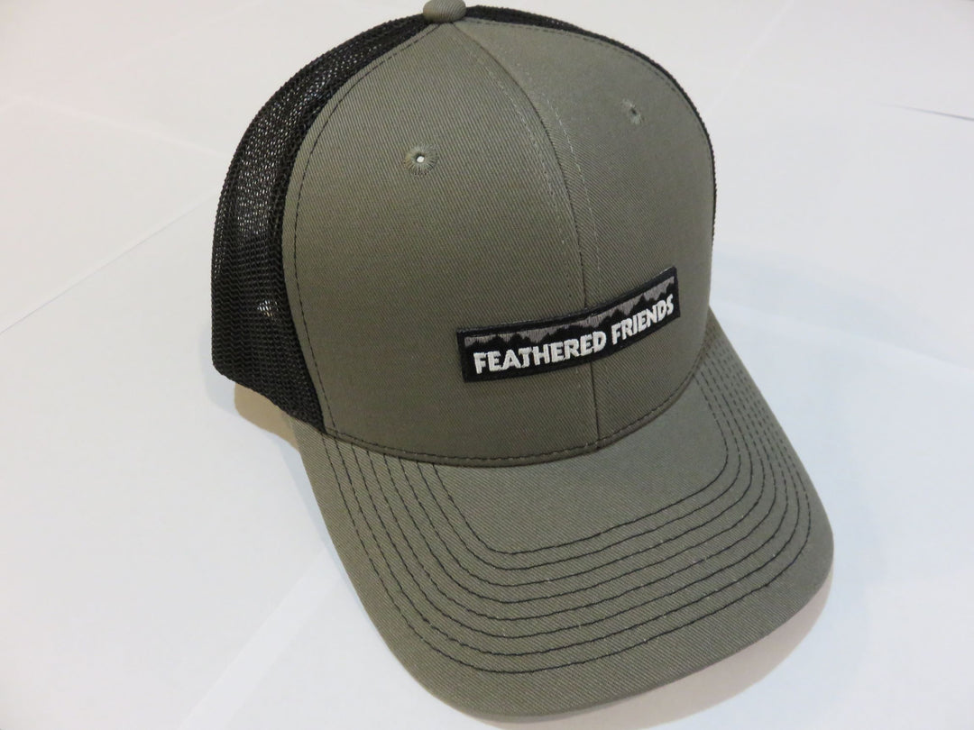 Studio image Feathered Friends Pro Style Mountain Logo Trucker Hat olive and black colors