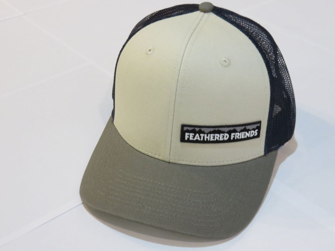 Studio image Feathered Friends Pro Style Offset Logo Trucker Hat natural olive and navy colors