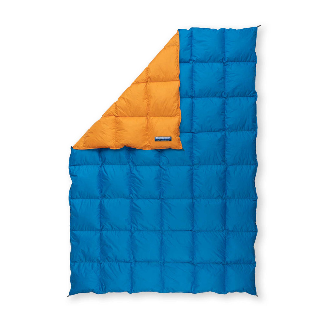 Feathered Friends blue and orange ultralight down blanket on white background