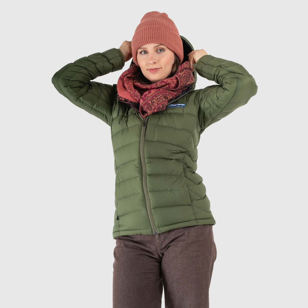 Studio front view of woman wearing a chive green Women's Feathered Friends Eos Down Jacket