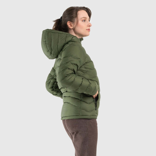 Studio side view of woman wearing a chive green Women's Feathered Friends Eos Down Jacket