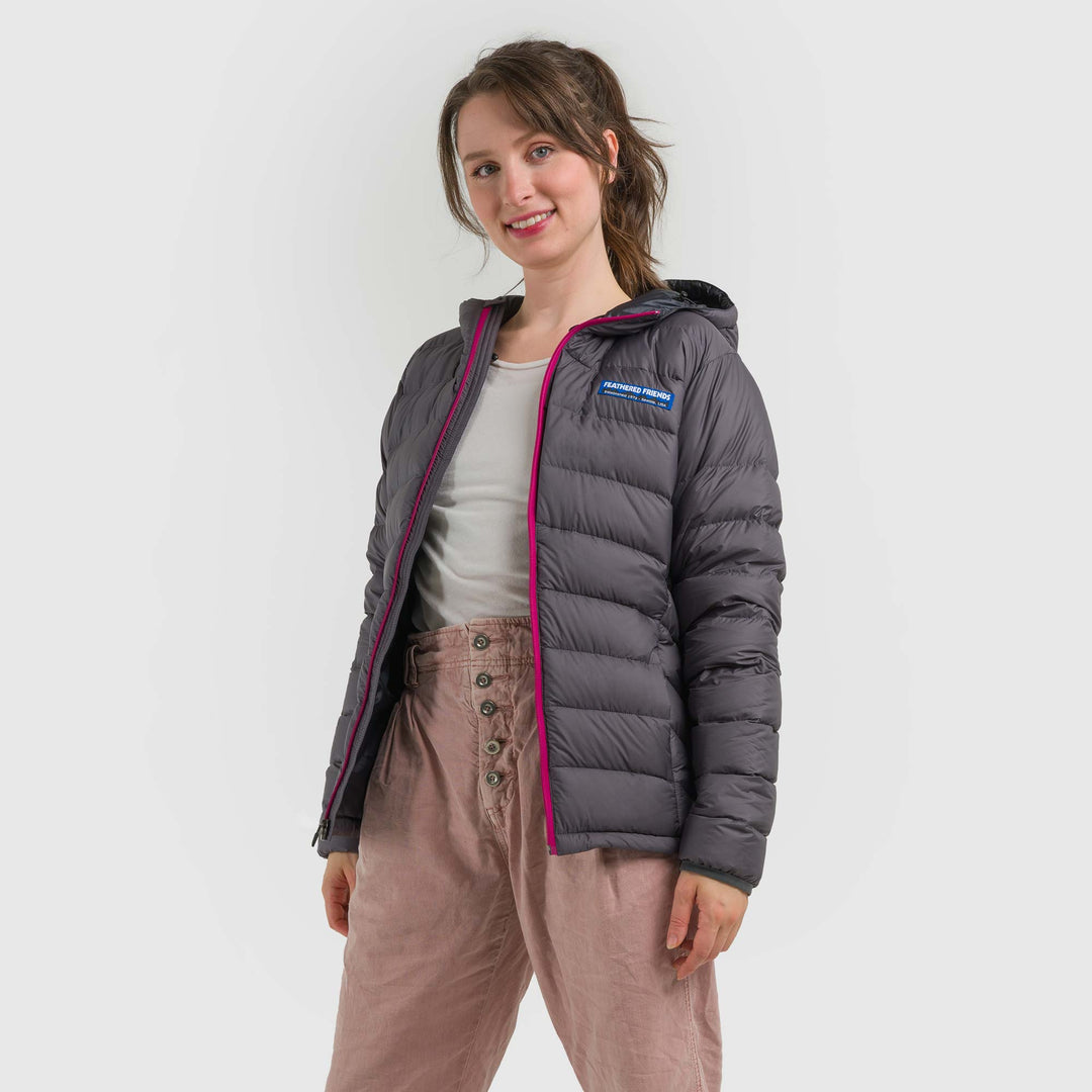 Studio front view of a woman wearing a steel gray Women's Feathered Friends Eos Down Jacket