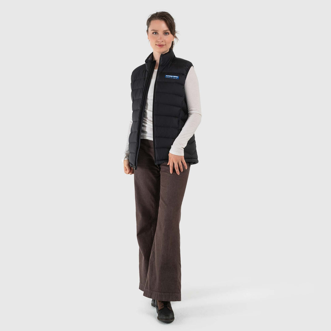 Studio front view of a woman wearing a black Women's Feathered Friends Eos Down Vest