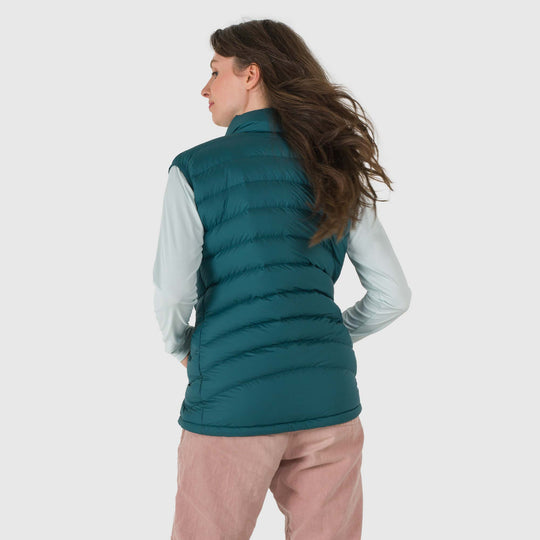 Studio back view of a woman wearing a deep teal Women's Feathered Friends Eos Down Vest