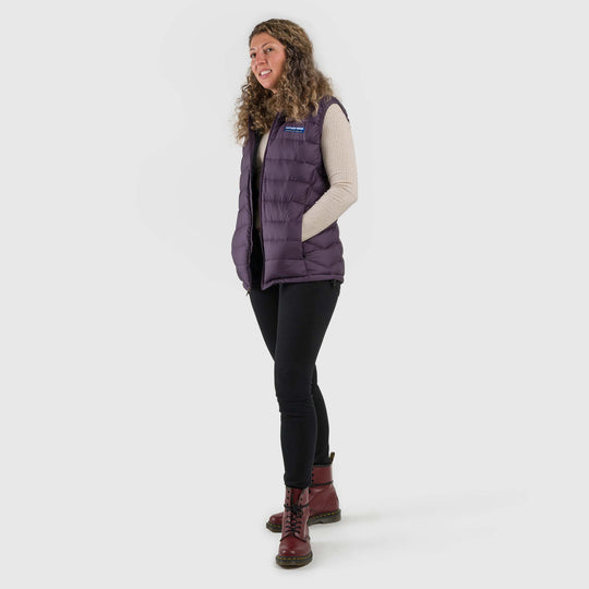 Studio front view of a woman wearing a dusky purple Women's Feathered Friends Eos Down Vest