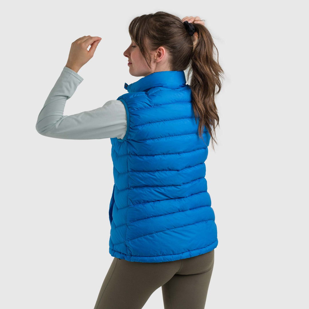 Studio back view of a woman wearing a sky blue Women's Feathered Friends Eos Down Vest