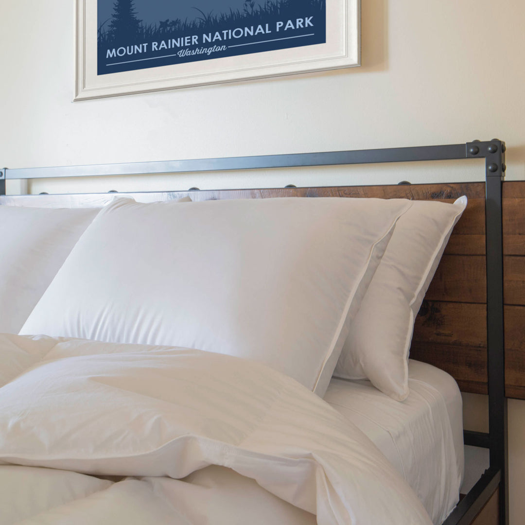 Feathered Friends 850 Fill Down Pillows on a bed with wood and metal headboard