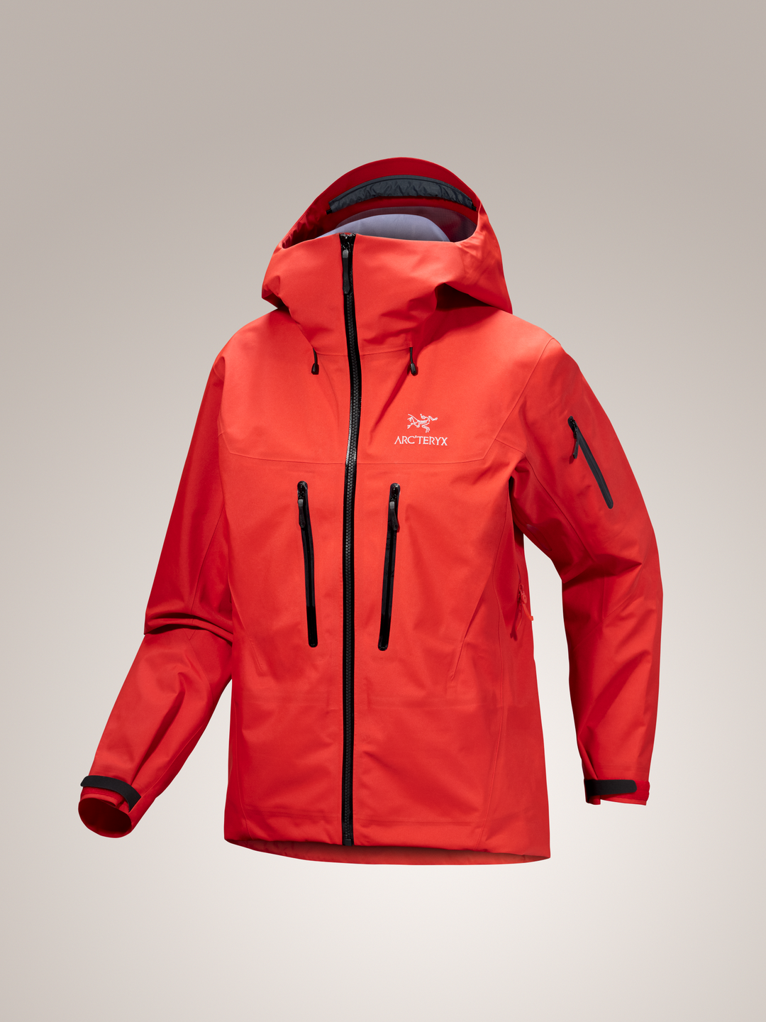 Red Arc'teryx Alpha SV jacket with black zippers on a gray background