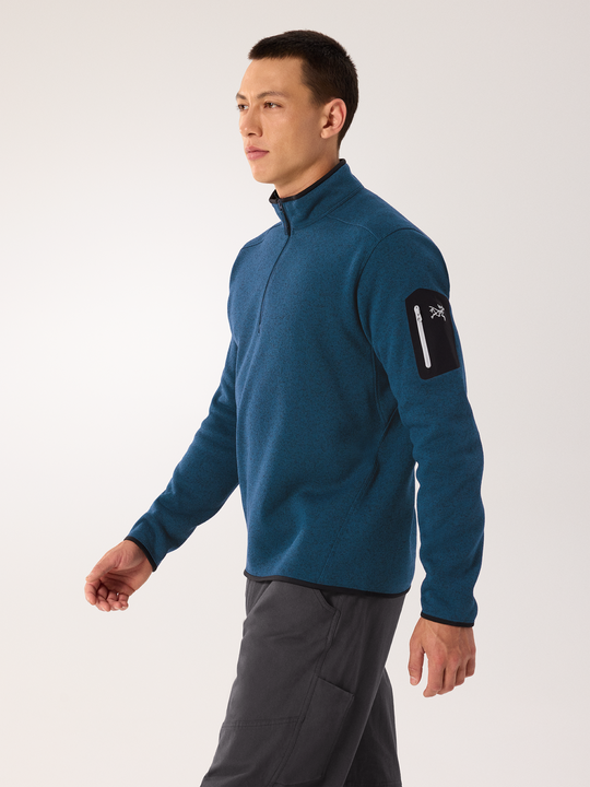 Man wearing a blue Arc'teryx  Covert jacket with a brand logo on a white background