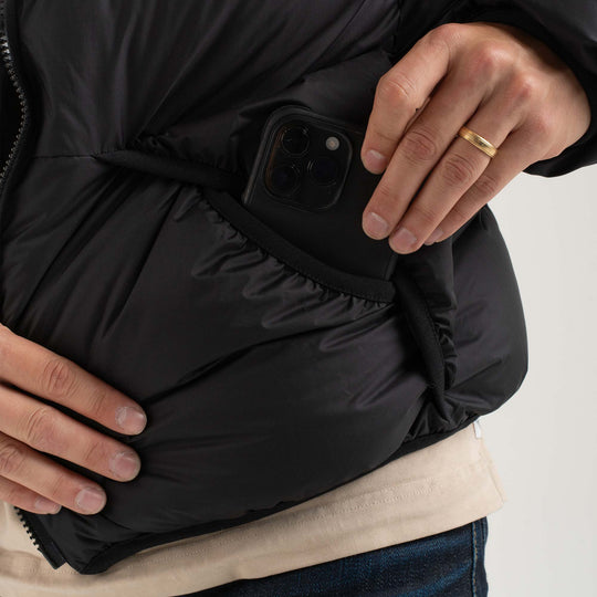 Studio detail view of a phone being pulled out of external pocket of Helios Down Puffer Jacket