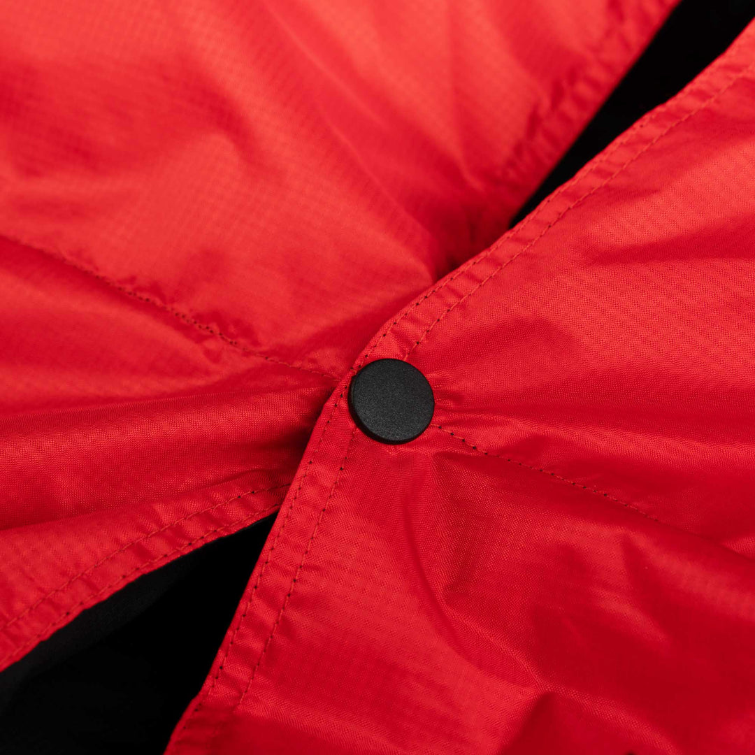 Close up of a snap button detail on Red and Black Feathered Friends down blanket