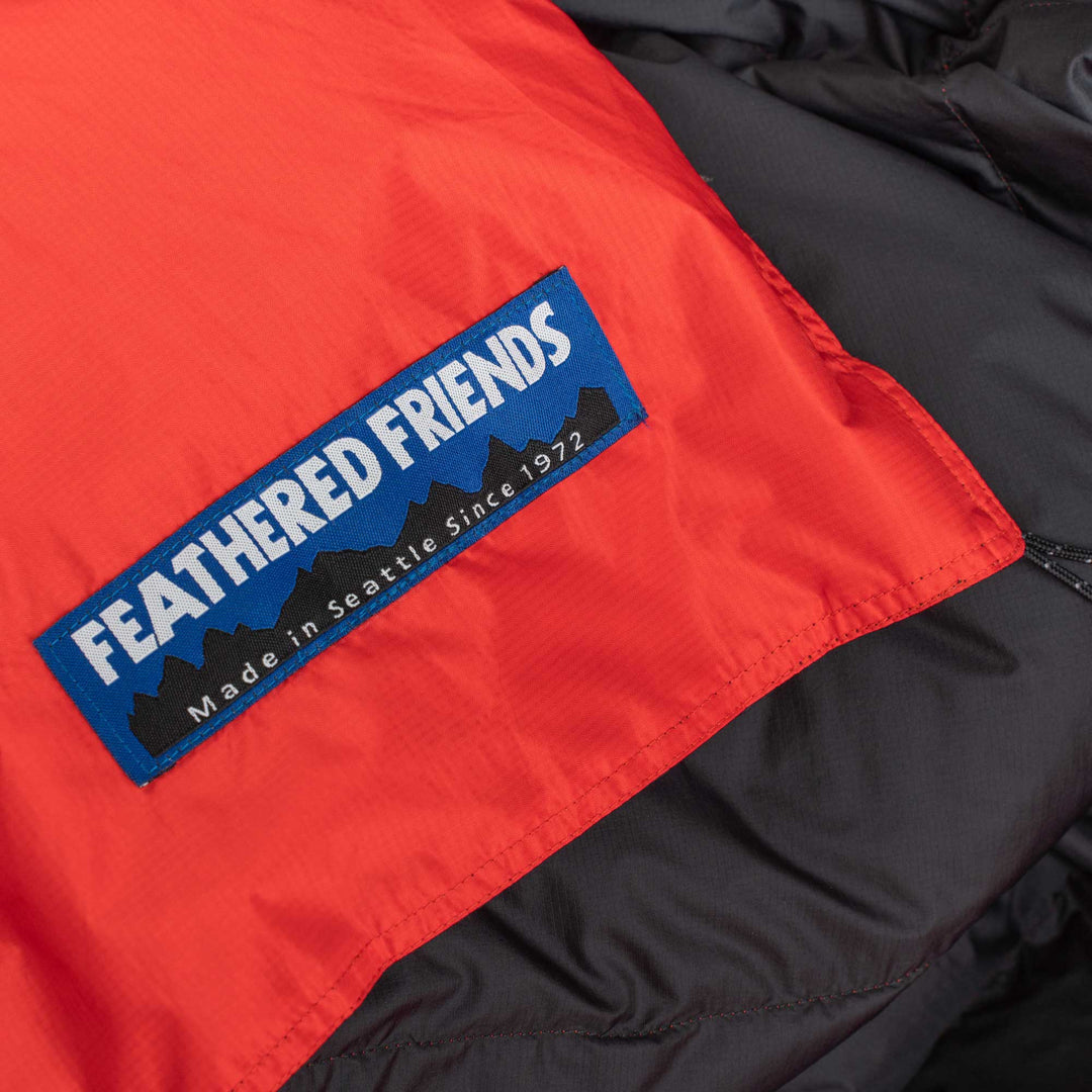 Close up of logo of a red and black Feathered Friends water-resistant down blanket