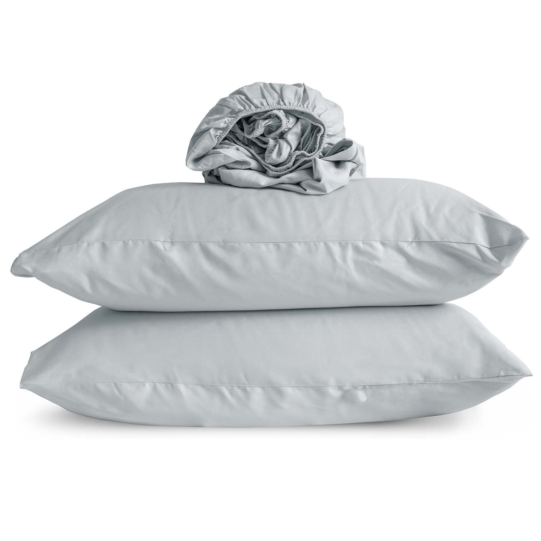 Studio photo of Horizon blue-color Feathered Friends Organic Cotton Fitted Sheet rolled up on two pillow cases