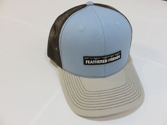 Studio image Feathered Friends Pro Style Mountain Logo Trucker Hat light blue and natural brown colors