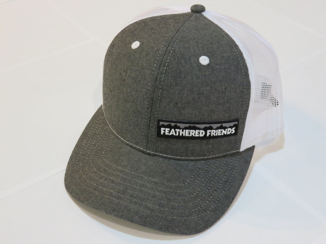 Studio image Feathered Friends Pro Style Offset Logo Trucker Hat black chambray and white colors