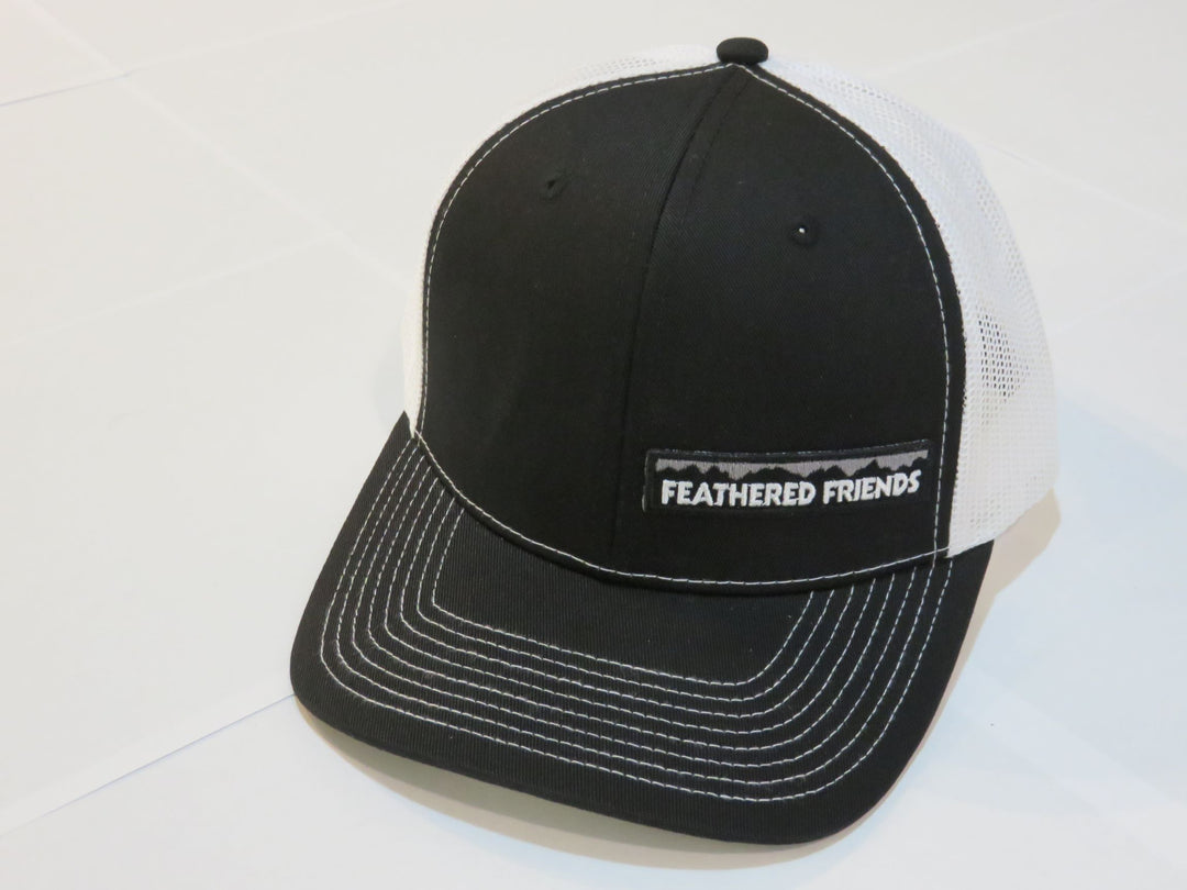 Studio image Feathered Friends Pro Style Offset Logo Trucker Hat black and white colors