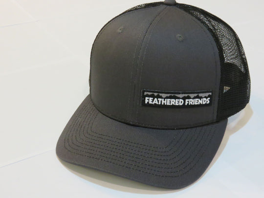 Studio image Feathered Friends Pro Style Offset Logo Trucker Hat dark grey and black colors