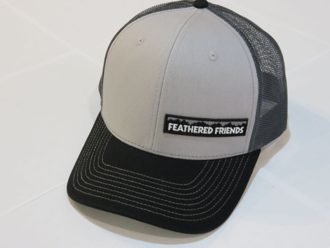Studio image Feathered Friends Pro Style Offset Logo Trucker Hat grey and black colors