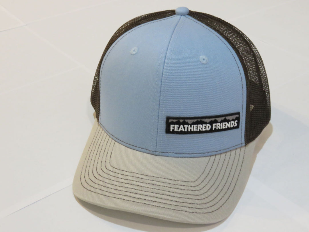 Studio image Feathered Friends Pro Style Offset Logo Trucker Hat light blue and brown colors