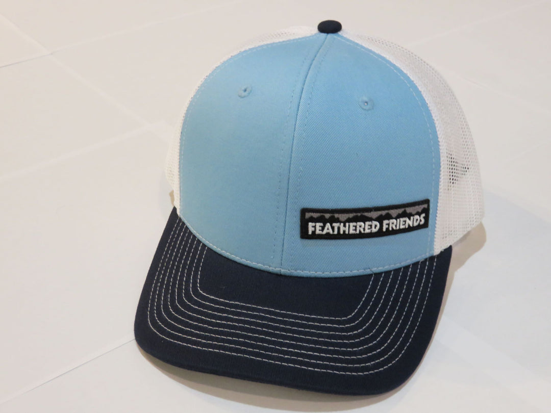 Studio image Feathered Friends Pro Style Offset Logo Trucker Hat light blue, navy, and white colors