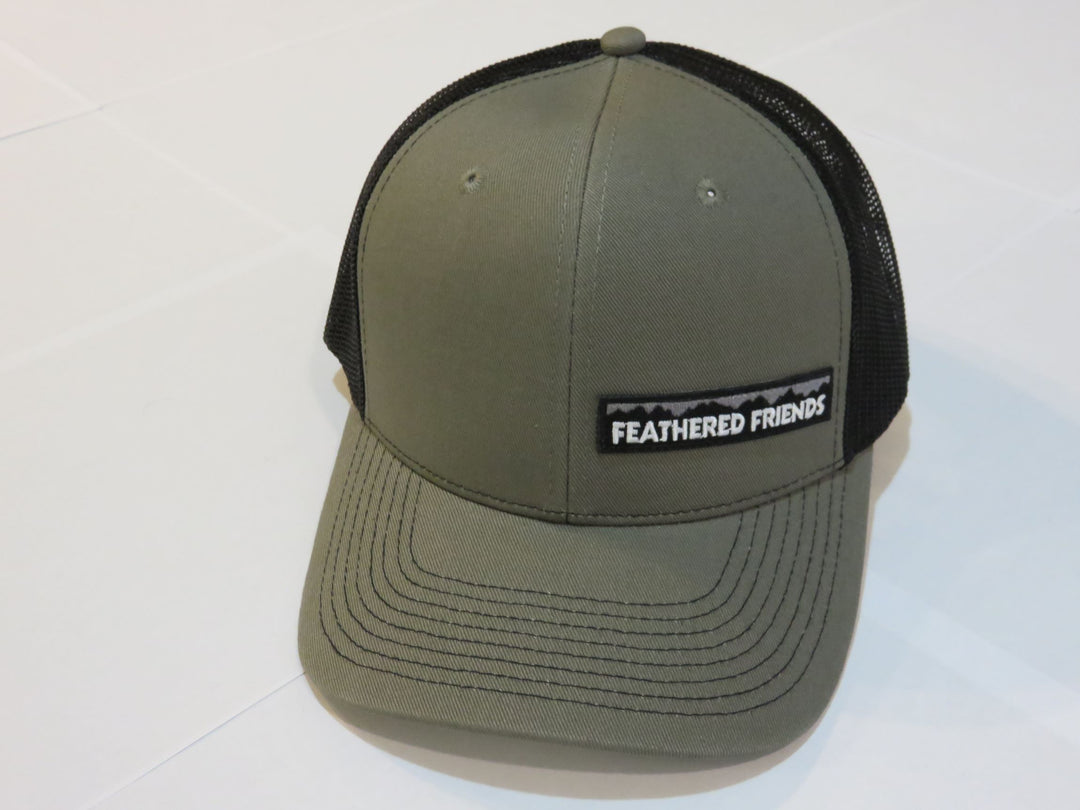 Studio image Feathered Friends Pro Style Offset Logo Trucker Hat olive and black colors