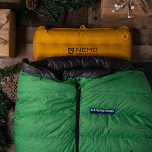 Feathered Friends Sleeping Bag on Nemo Sleeping Pad with holiday boxes and pine branches