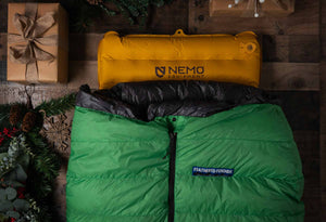 Feathered Friends Sleeping Bag on Nemo Sleeping Pad with gift boxes and pine branches