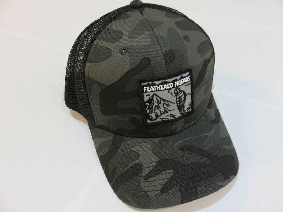 Studio image Feathered Friends Smoking Man Pro Style Trucker Hat Black and Black Camo colors
