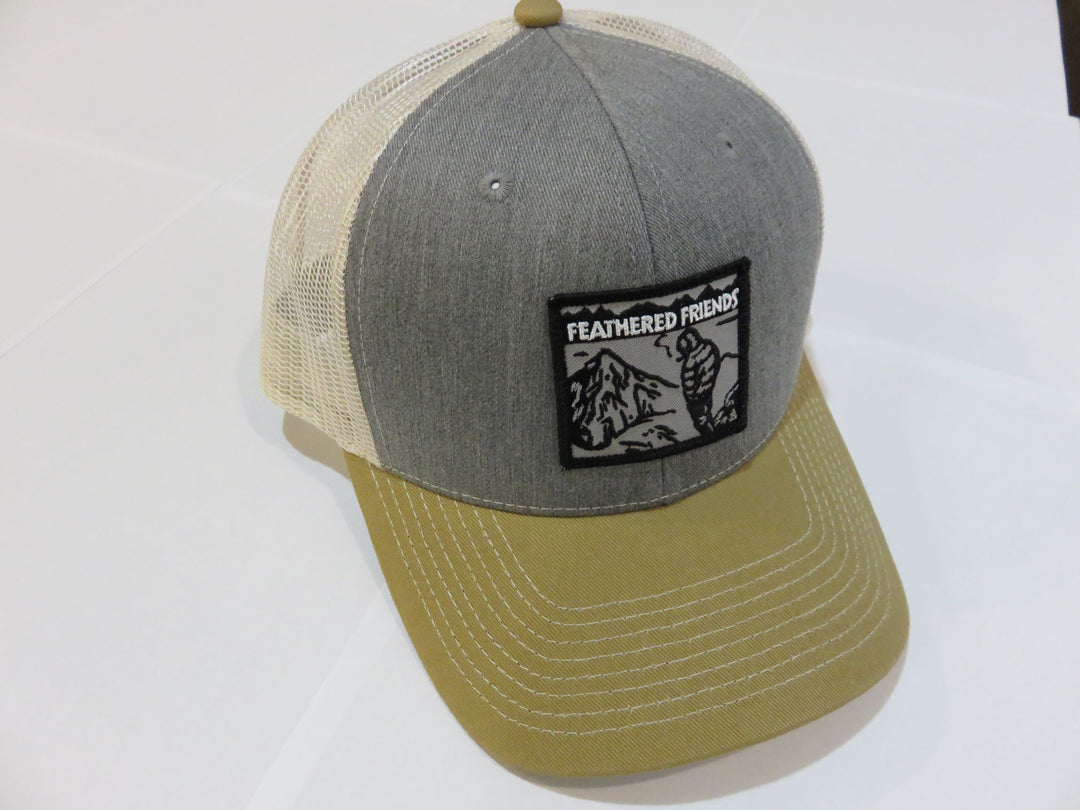 Studio image Feathered Friends Smoking Man Pro Style Trucker Hat heather gray amber stone colors