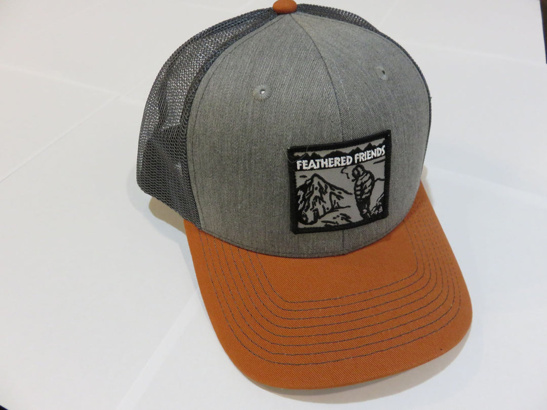 Studio image Feathered Friends Smoking Man Pro Style Trucker Hat gray burnt orange charcoal colors