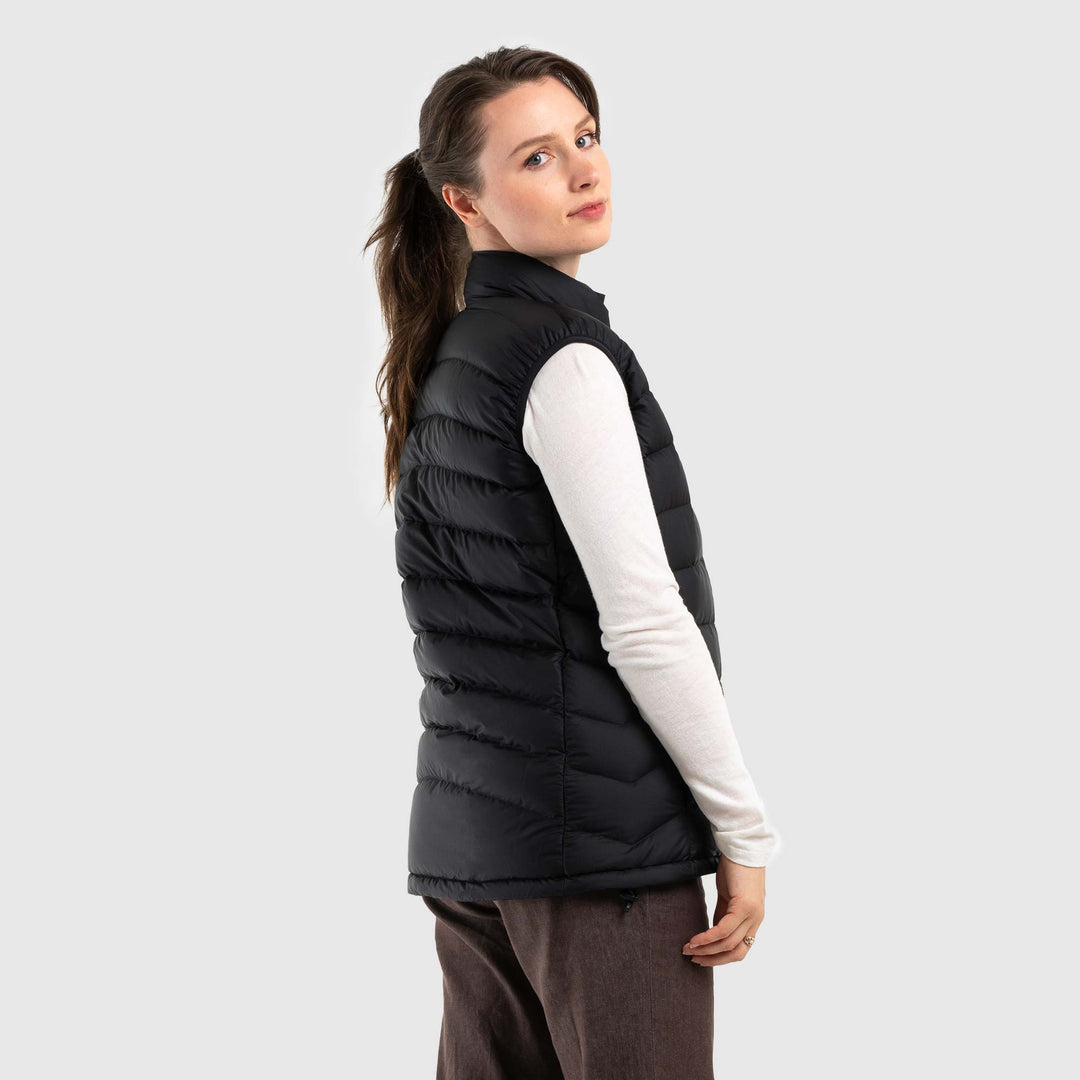 Studio back view of a woman wearing a black Women's Feathered Friends Eos Down Vest