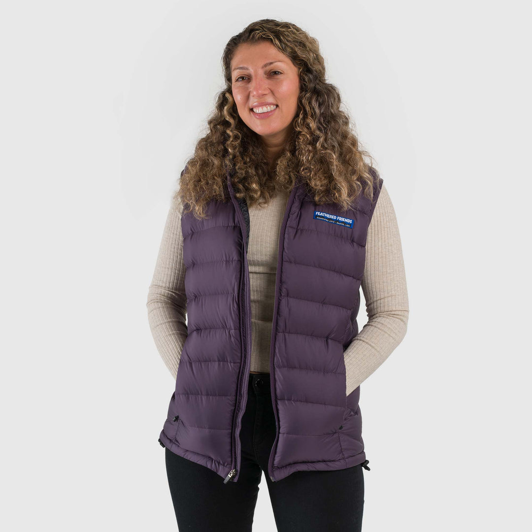 Studio front view of a woman wearing a dusky purple Women's Feathered Friends Eos Down Vest